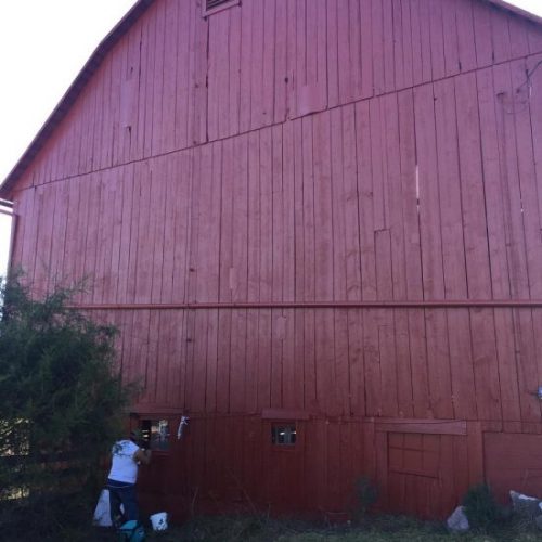 Red barn in Leesburg with a fresh coat of paint, preserving its structure and historic charm.