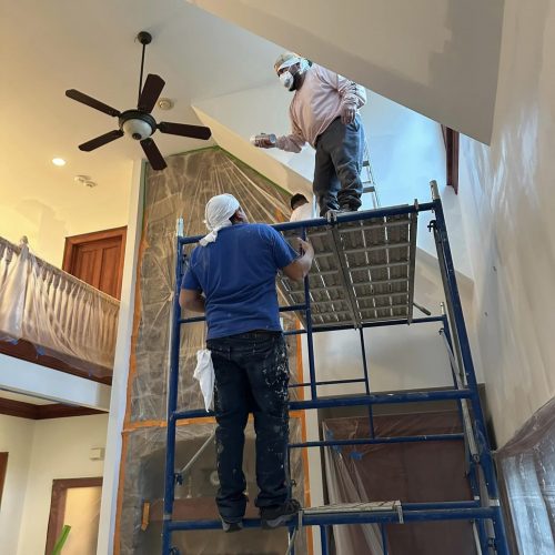 painting wall on scaffold